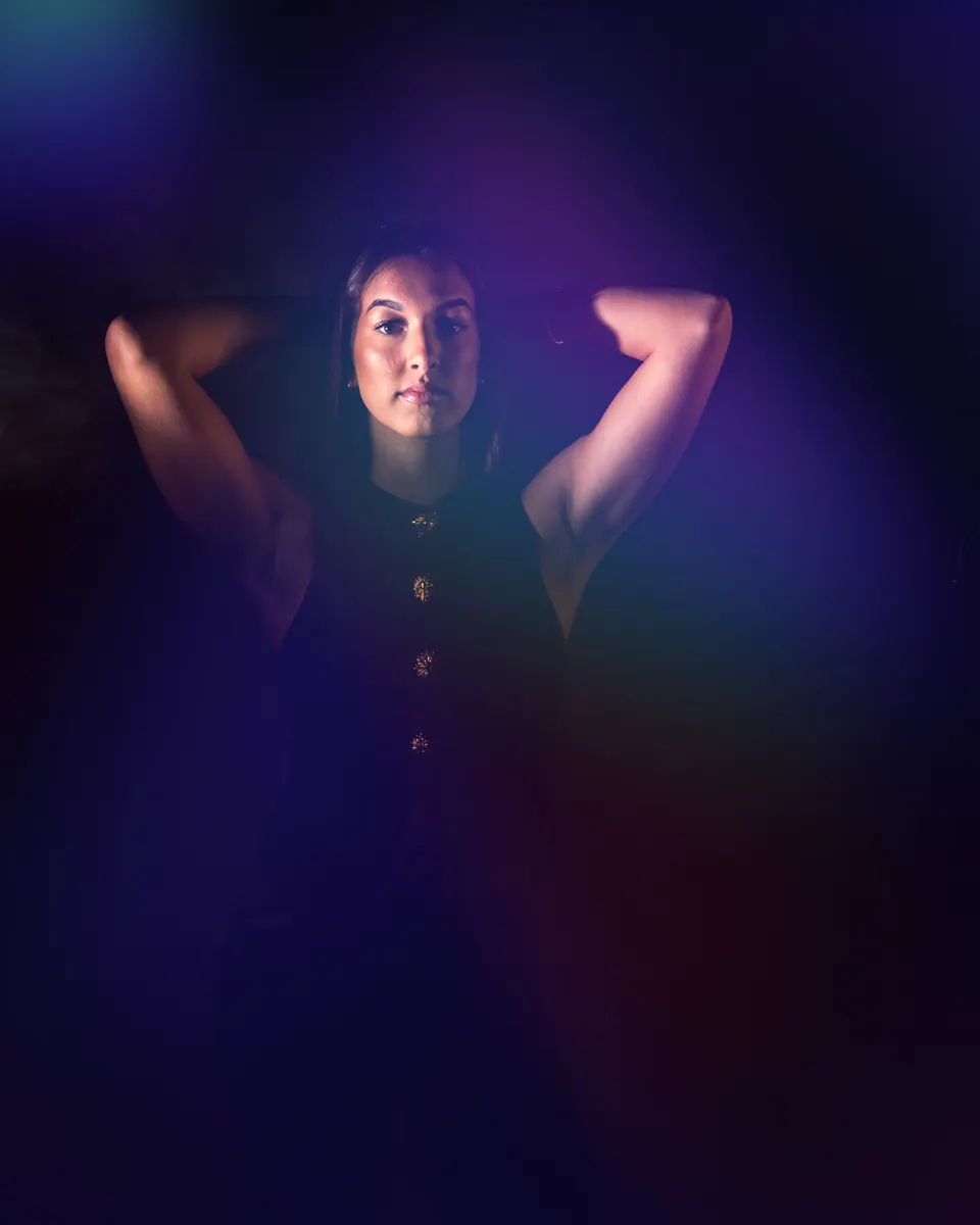 Donker creatief studioportret met blauwe en paarse verlichting