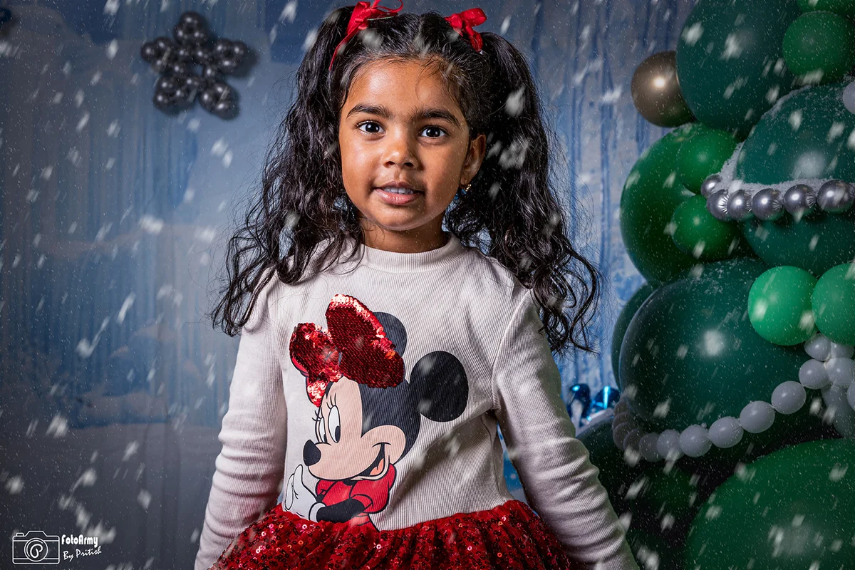 Kind met rode haarstrikken in een winterse kerstsetting met een sneeuweffect