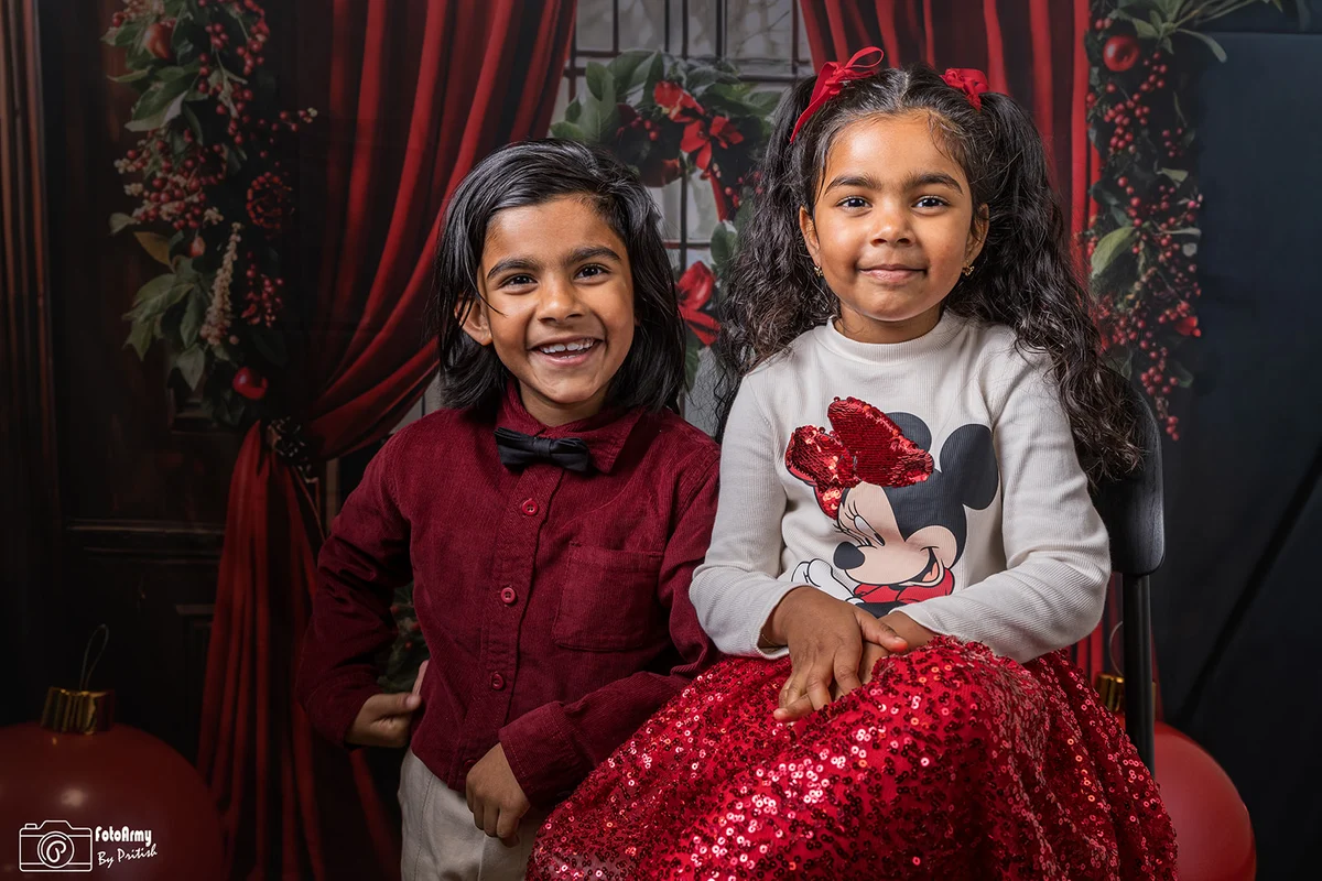 Twee kinderen samen in een rode kerstsetting