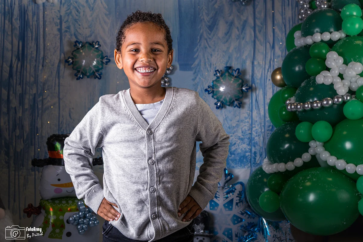 Lachend kind bij een kerstboom in een winterse setting